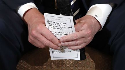 Le président américain Donald Trump tient une fiche avec des questions lors de sa rencontre avec des rescapés de la fusillade dans un lycée en Floride, le 21 février 2018 à la Maison Blanche, à Washington.&nbsp; (CAROLYN KASTER / AP / SIPA)