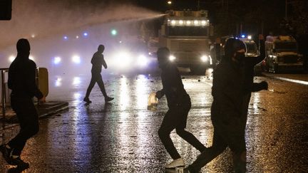 La police utilise un canon à eau contre des manifestants nationalistes sur Springfield Road, à Belfast, le 8 avril 2021. (PAUL FAITH / AFP)