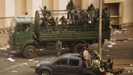 Des soldats se regroupent devant les bureaux de la t&eacute;l&eacute;vision d'Etat apr&egrave;s avoir annonc&eacute; un putsch, le 22 mars 2012 &agrave; Bamako, la capitale du Mali.&nbsp; (MALIN PALM / REUTERS)