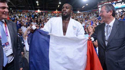 Teddy Riner accompagné par Patrick Balkany après sa médaille d'or aux JO de Londres (EMMANUEL DUNAND / AFP)