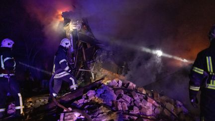 Firefighters try to put out a fire in a building after a Russian strike, December 31, 2023, in Kharkiv, Ukraine.  (YEVHEN TITOV / ANADOLU / AFP)