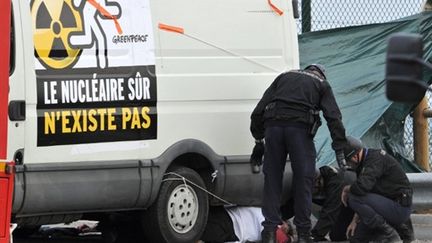 Des gendarmes s'apprêtent à évacuer un militant de Greenpeace, à Flamanville, le 2 mai 2011. (AFP - Jean-Paul Barbier)