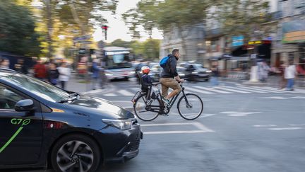 Un cycliste traverse la rue de Rivoli à Paris, le 23 octobre 2024. (GREGOIRE CAMPIONE / AFP)