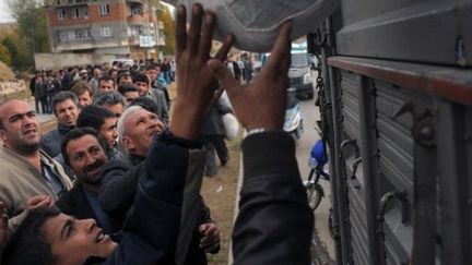 Des survivants sans abri du tremblement de terre reçoivent de l'aide à Ercis. (DIMITAR DILKOFF / AFP)