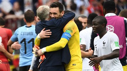 Le sélectionneur Didier Deschamps enlace son capitaine Hugo Lloris sous le regard de N'Golo Kanté (à droite) après la victoire contre l'Uruguay, vendredi 6 juillet 2018 à&nbsp;Nijni Novgorod (Russie). (FRANCK FIFE / AFP)