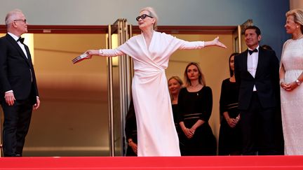 Entourée du directeur du Festival de Cannes Thierry Frémaux et de sa présidente Iris Knobloch, l'immense actrice américaine Meryl Streep ouvre et tend les bras en haut des marches du Palais lors de la cérémonie d'ouverture.  Un geste qui fait écho à toutes les magnifiques performances offertes au public au cours d'une carrière exceptionnelle.  Invitée d'honneur du festival, elle revient sur la Croisette 35 ans après avoir remporté son Prix d'interprétation pour 