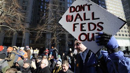 Un employé gouvernemental opposé à la construction d'un mur entre les Etats-Unis et le Mexique manifeste son hostilité au projet dans les rues de Boston, vendredi 11 janvier 2019. (JOSEPH PREZIOSO / AFP)