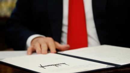 Donald Trump signe le décret qui met fin à la séparation des familles de migrants à la frontière entre les Etats-Unis et le Mexique, le 20 juin 2018. (YURI GRIPAS / REUTERS)