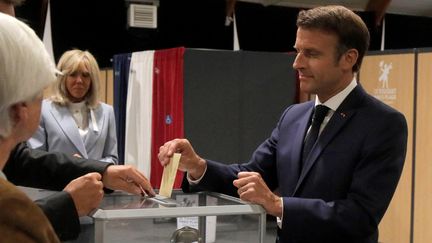 Emmanuel Macron vote en compagnie de son épouse, Brigitte Macron, le 19 juin 2022 au Touquet (Pas-de-Calais) lors du&nbsp;second tour des élections législatives. (MICHEL SPINGLER / AFP)