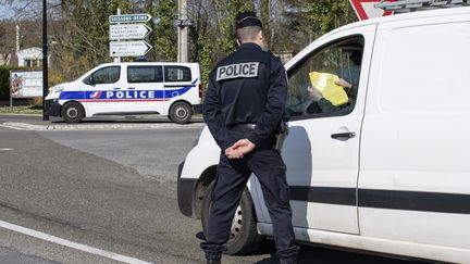 Un&nbsp;policier&nbsp;réalise un contrôle d'attestation de déplacement à Compiègne (Oise), dimanche 26 mars. (ANTONI LALLICAN / HANS LUCAS)