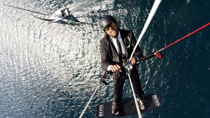 Alex Thomson survolant en kitesurf son "Hugo Boss", lors d'un spot de promotion.&nbsp; (AlexThomsonRacing)