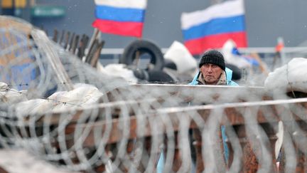 Un militant prorusse garde une barricade pr&egrave;s du b&acirc;timent des services de s&eacute;curit&eacute;, le 11 avril 2014 &agrave; Lugansk, dans l'est de l'Ukraine. (GENYA SAVILOV / AFP)