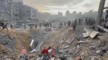 An image taken from AFPTV video footage shows Palestinians searching for survivors in a crater after an attack on a refugee camp in Jabaliya, northern Gaza Strip, October 31, 2023. (FADI ALWHIDI / AFP)