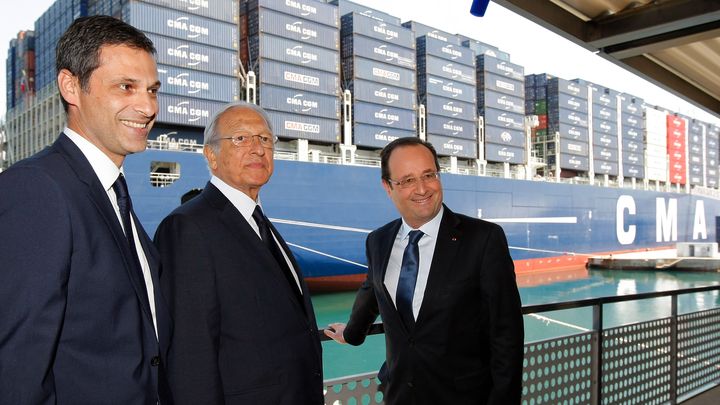 François Hollande pose avec Jacques et Rodolphe Saadé le 4 juin 2013 devant le "Jules Verne", à l’époque le plus grand porte-conteneurs du monde. (CLAUDE PARIS / POOL / AFP)