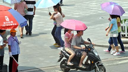 Zhengzhou (Chine), 36&deg;C, le 1er juillet 2012. Port des ombrelles quasi obligatoire dans le centre du pays. (WANG SONG / XINHUA / AFP)