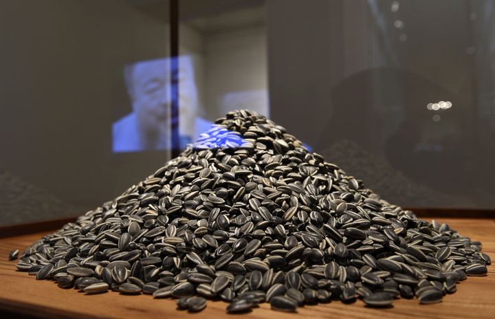 "Sun Flower Seeds" (graines de tournesol), installation d'Ai Weiwei exposée à Barcelone. Dans la vitre, on voit le visage de l'artiste, reflet d'une vidéo (3 novembre 2011)
 (Lluis Gene / AFP)