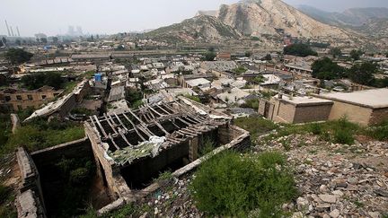 des centaines de petites mines ont été ouvertes illégalement sous terre ou à ciel ouvert. A l’apogée de l’industrie houillère, les prix et les profits ont grimpé encouragent les mineurs à creuser plus loin et plus profond, empiétant sur des zones résidentielles et les terres agricoles. Les habitants ici se livrent à une course contre la montre pour éviter le naufrage de leur village et sauvegarder leurs maisons.  (REUTERS/Jason Lee)