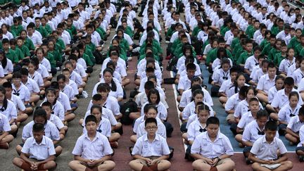 Tout le pays&nbsp;retient son souffle. Dans cette école de Chiang Rai, située à une&nbsp;soixantaine de kilomètres de la grotte,&nbsp;2 000 étudiants et professeurs ont participé à une prière collective. (PATIPAT JANTHONG / BANGKOK POST / AFP)