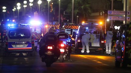 Des officiers de police et des secours arrivent sur la scène de l'attaque, jeudi 14 juillet 2016, sur la promenade des Anglais à Nice (Alpes-Maritimes). (VALERY HACHE / AFP)