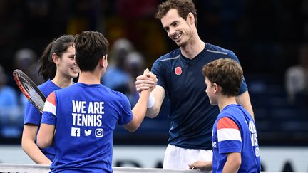 Andy Murray savoure sa couronne en compagnie de jeunes ramasseurs de balle aux anges. (MIGUEL MEDINA / AFP)