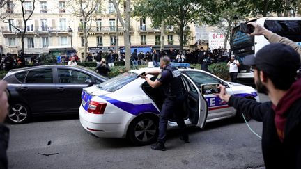 Un policier a pointé son arme vers des manifestants d'une marche contre les violences policières, à Paris, le 23 septembre 2023. (OLIVIER ARANDEL / MAXPPP)