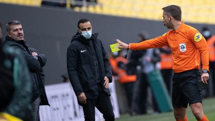 L'arbitre Johan Hamel (à droite) donne un carton jaune lors d'un match de Ligue 1, au stade de la Beaujoire à Nantes, le 13 février 2022. (LOIC VENANCE / AFP)