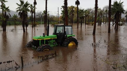 Un tracteur abandonné dans une zone inondée de Roquebrune-sur-Argens (Var), le 24 novembre 2019.&nbsp; (VALERY HACHE / AFP)