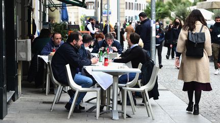 Des personnes déjeunent en terrasse à Milan, le 26 avril 2021, alors que certaines restrictions contre le Covid-19 ont été levées en Italie. (PIER MARCO TACCA / AFP)