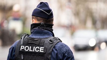 Un policier de dos dans les rues de Paris, le 13 mars 2022. (XOSE BOUZAS / HANS LUCAS / AFP)