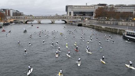 Course de "stand up paddle" sur la Seine &agrave; Paris, le 4 d&eacute;cembre 2011. (ALEXANDER KLEIN / AFP)