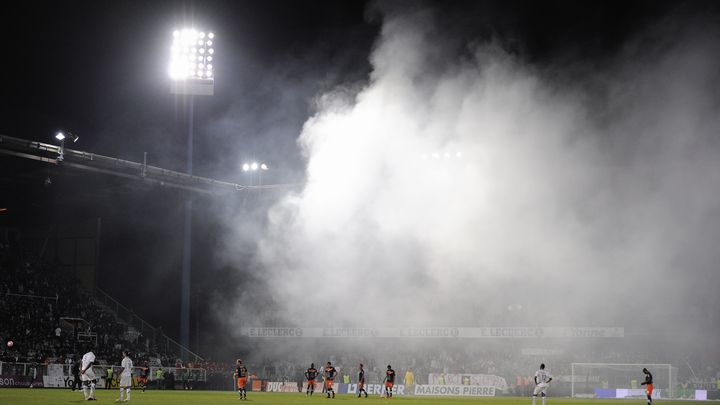 Les joueurs du match Auxerre-Montpellier lors de la seconde interruption du match, &agrave; cause d'un fumig&egrave;ne, le 20 mai 2012, &agrave; Auxerre.&nbsp; (JEFF PACHOUD / AFP)