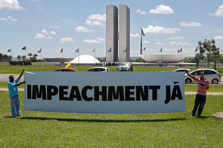 Des manifestants ont déployé une banderole pour protester contre la gestion de la pandémie par Jair Bolsonaro, le 23 janvier 2021, à&nbsp;Brasilia. (SERGIO LIMA / AFP)