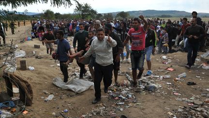 Des migrants tentent de passer la fronti&egrave;re entre la Gr&egrave;ce et la Mac&eacute;doine, le 21 ao&ucirc;t 2015. (SAKIS MITROLIDIS / AFP)