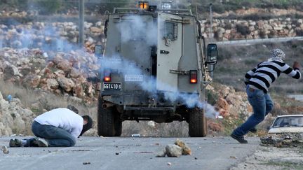 Le manifestant&nbsp;Moustapha Abderrazek al-Tamimi, &agrave; gauche, prostr&eacute; avoir re&ccedil;u une grenade lacrymog&egrave;ne au village de Nabi Saleh (Cisjordanie), le 9 d&eacute;cembre 2011. (HAIM SCHWARCZENBERG / AFP)