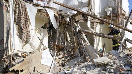 Un pompier fouille les d&eacute;bris de l'immeuble de Rosny-sous-Bois (Seine-Saint-Denis), apr&egrave;s l'explosion du dimanche 31 ao&ucirc;t 2014. (BERTRAND GUAY / AFP)