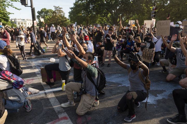 Des manifestants posent un genou à terre, lors d'une&nbsp;marche&nbsp;après la mort de George Floyd, près de la Maison Blanche, à Washington DC, le 1er juin 2020. (ROBERTO SCHMIDT / AFP)