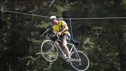 Pas toujours facile de trouver une bonne place pour admirer les coureurs. Le 22 juillet, lors de l'&eacute;tape reliant&nbsp;Digne-les-Bains &agrave; Pra Loup, ce spectateur a trouv&eacute; la solution : une tyrolienne offrant un point de vue unique sur le peloton. (STEFANO RELLANDINI / REUTERS / X90016)