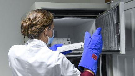 Une soignante récupère des doses de vaccin Pfizer/BioNTech dans un congélateur spécial, le 27 décembre 2020 à Louvain (Belgique). (FREDERIC SIERAKOWSKI / AFP)