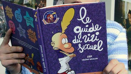 Un enfant lit "Le Guide du zizi sexuel", le 2 mars 2002 à Jouy-en-Josas (Yvelines). (MAXPPP)