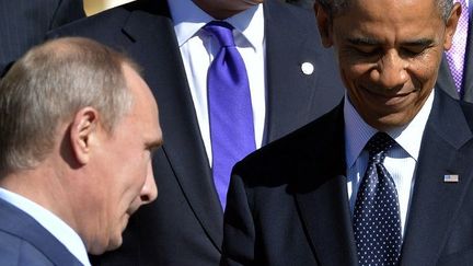 Président de la Russie Vladimir Poutine (G) passe devant le président américain Barack Obama afin de poser pour la photo de famille lors du sommet du G20, le 6 Septembre 2013, à Saint-Pétersbourg. (AFP PHOTO / JEWEL SAMAD)