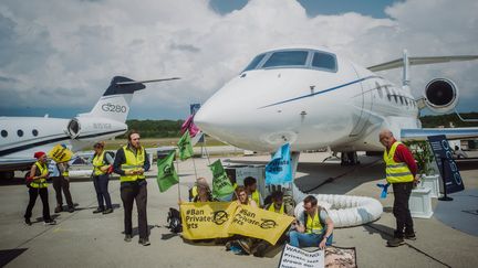 Des activistes du climat près d'un jet à l'aéroport de Genève (Suisse), le 23 mai 2023. (THOMAS WOLF / GREENPEACE / AFP)