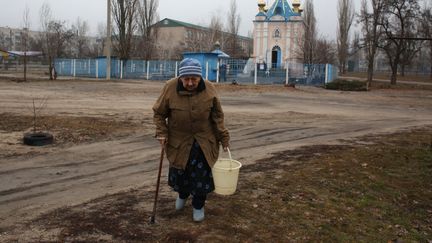 Une habitante récupère de l'eau à&nbsp;Chtchastia, ville de l'oblast de Lougansk en Ukraine, le 23 février 2022. (ANATOLII STEPANOV / AFP)