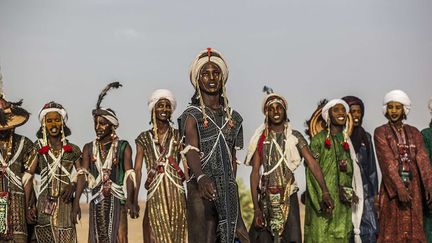 les hommes doivent aussi revêtir de magnifiques vêtements qu’ils ont créés la plupart eux-mêmes pendant une année. Ils se parent de colliers de perles et de coquillages et accrochent  une plume d'autruche sur leur turban. Souvent, ils enfilent un pagne de femme par-dessus un vêtement de peau. Et font pendre dans leurs le dos un barbol, une chaîne faite de coquillages dont l’extrémité est une minuscule calebasse. Féminiser son apparence est le plus sûr moyen de séduire la gent féminine. Un grand classique chez les Wodaabes. (Mario Gerth/HotSpot Media/SIPA)