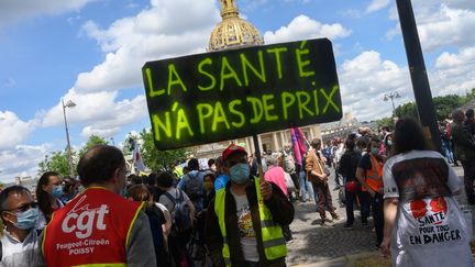 Un manifestant portant un masque brandit une pancarte "La santé n'a pas de prix" lors d'un rassemblement du personnel soignant le 16 juin 2020. (ESTELLE RUIZ / HANS LUCAS)