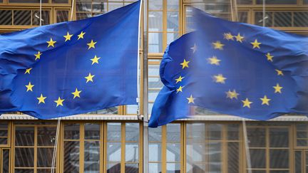 Des drapeaux de l'Union européenne devant le bâtiment du Conseil européen à Bruxelles, le 17 mars 2022. (KENZO TRIBOUILLARD / AFP)