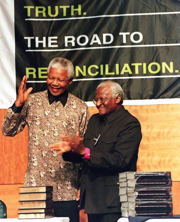 L'ancien président sud-africain Nelson Mandela et Mgr Desmond Tutu, alors président de la Commission vérité et réconciliation (TRC), lors de la remise du rapport de cette instance le 29 octobre 1998. (AFP - WALTER DHLADHLA)