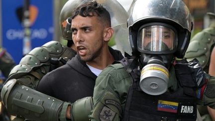 Members of the Bolivarian National Guard's riot squad arrest opponents of Venezuelan President Nicolas Maduro who were participating in a protest, in the Chacao neighborhood of Caracas, Venezuela, on July 30, 2024. (YURI CORTEZ / AFP)