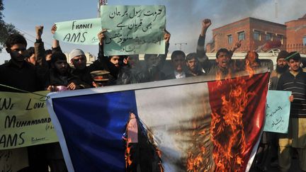 Des manifestants br&ucirc;lent un drapeau fran&ccedil;ais lors d'un d&eacute;fil&eacute; anti-Charlie Hebdo &agrave; Peshawar (Pakistan), le 19 janvier 2015. (A. MAJEED / AFP)