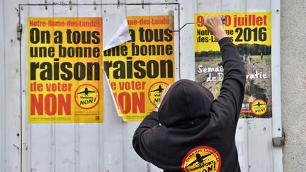 Un militant colle des affiches invitant à voter "non" au projet d'aéroport à Notre-Dame-des-Landes, le 13 juin 2016. (LOIC VENANCE / AFP)