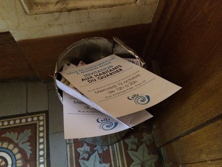 Des tracts de l'association Gaïa invitant les riverains de&nbsp;la "salle de consommation à moindre risque" à venir la visiter,&nbsp;jetés dans une corbeille d'un hall d'immeuble voisin, le 11 octobre 2016, dans le 10e arrondissement de Paris. (BENOIT ZAGDOUN / FRANCEINFO)